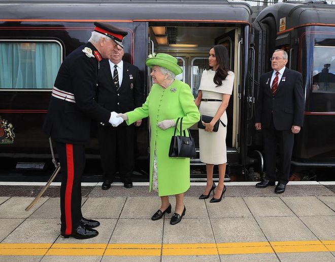 Queen Elizabeth and Meghan, Duchess of Sussex exit the Royal Train at Runcorn Station in Cheshire in the north of England. Photo: Getty