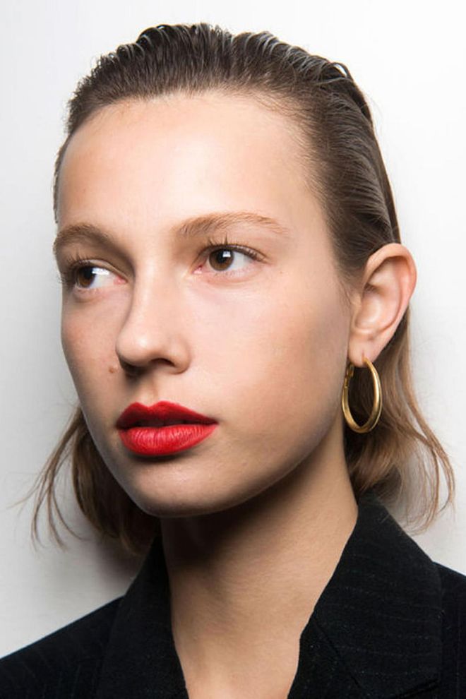 The Look: Not Your Average Red
How-To: Jason Wu has always had a penchant for classic beauty. The man loves a red lip as much as the rest of us. This season, Wu served up exactly what you'd expect: a red lip. Kind of. Well, not really. "It's not your basic red, it's fluorescent red, if that exists," said makeup artist Yadim backstage. After applying a mix of two red lipsticks, he tapped some neon orange theater paint right in the center of the bottom lip. "It's a raver girl red," he says, imagining that girl thinking her basic red lipstick looks, well, basic. In his mind, she would smear on some neon paint before running out the door . The orange-red lips appeared on only a handful of models; the pop of color matched a similar shade on their gowns. All in all, it's the same Jason Wu girl we know and love, just cooler, sportier, and with a flair for neon. Photo: IMAXTREE