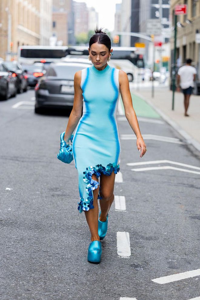 NEW YORK, NEW YORK - SEPTEMBER 09: Quigley wears blue asymmetric dress, metallic bag, platform shoes, earrings outside Tibi on September 09, 2023 in New York City. (Photo by Christian Vierig/Getty Images)