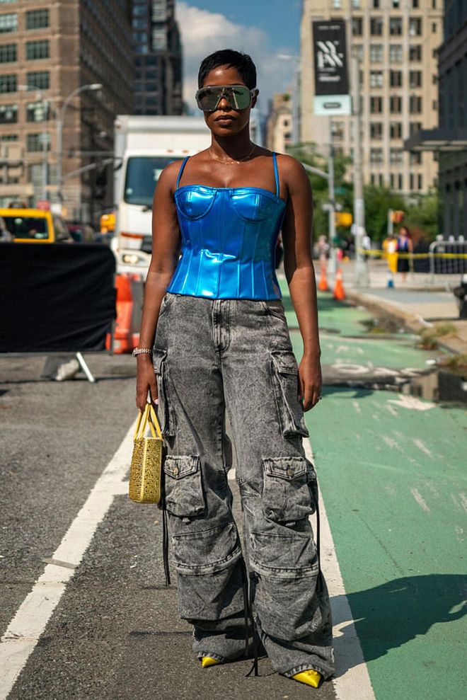NEW YORK, NEW YORK - SEPTEMBER 13: Jenee Naylor wearing a blue metallic fitted top with acid washed black cargo pants, along with a yellow handbag. (Photo by David Dee Delgado/Getty Images)