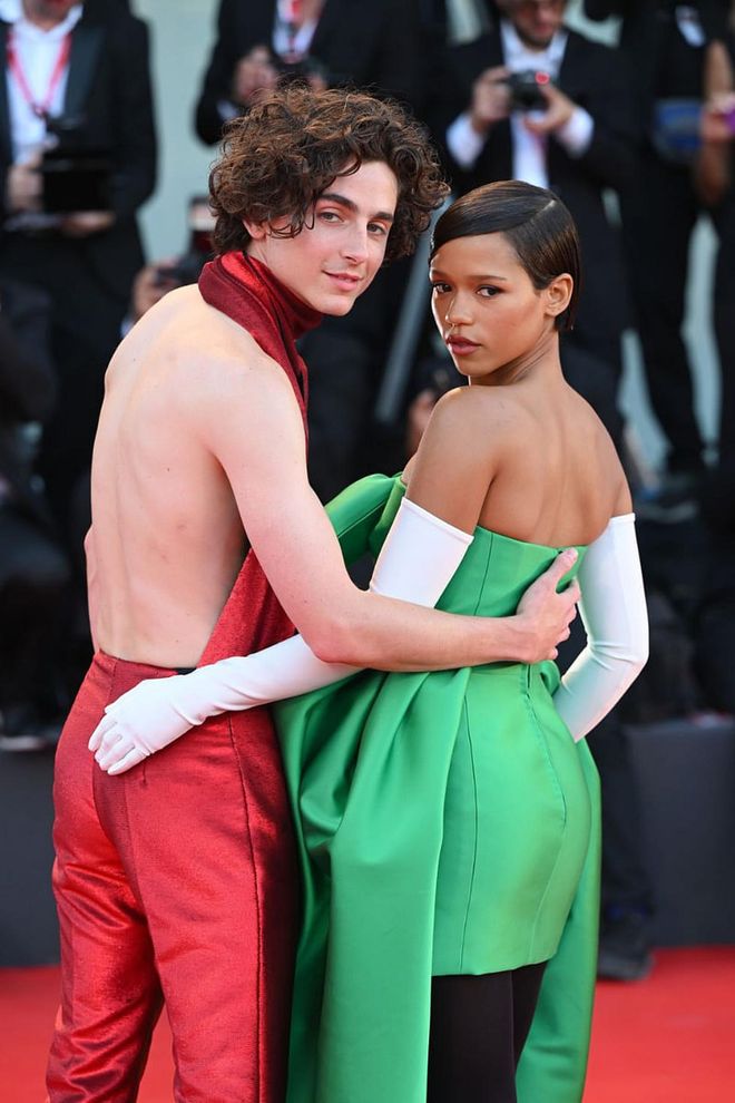 Timothée Chalamet in custom Haider Ackermann and Taylor Russell in Balenciaga haute couture, looking back at it, at the Venice Film Festival.