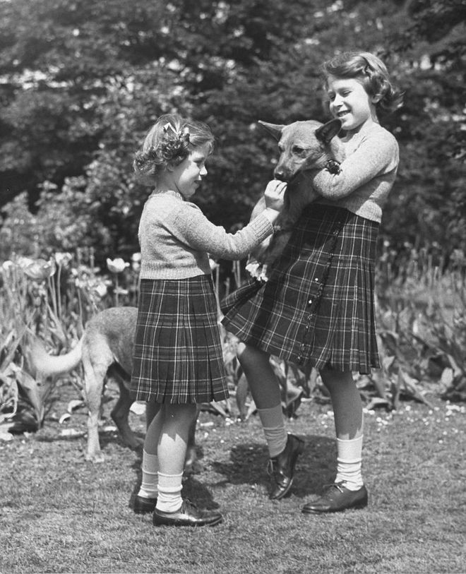 Elizabeth and Margaret sweetly play with a family corgi back in 1936 in Windsor. Not to be missed: the adorable matching outfits the sisters are wearing.
Photo: Getty 