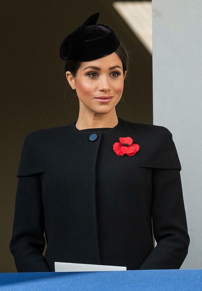 Fior Remembrance Day, Meghan wore a black buttoned-up coat, featuring capped sleeves, which she accessorized with a black hat. 