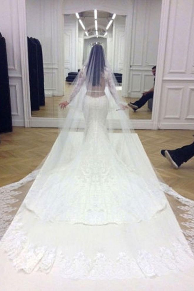For Kardashian's third wedding, this time to Kanye West in 2014, she wore a striking $400,000 Givenchy gown by designer Riccardo Tisci that featured a sheer back, lace sleeves and an incredible train.
