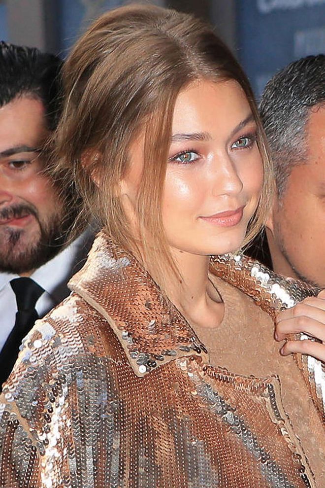Gigi Hadid is pure (rose) gold. Pair sheer washes of shimmer on the face and eyes with a statement coat.  