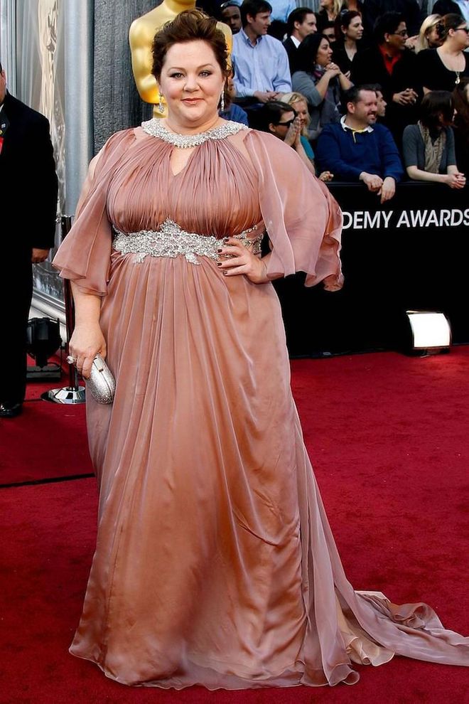McCarthy may have been nominated for a Best Supporting Actress Oscar for her hilarious turn in Bridesmaids, but she still couldn't find a designer to dress her for the 2012 Academy Awards.
<br><br>
"Two Oscars ago [in 2012], I couldn't find anybody to do a dress for me. I asked five or six designers - very high-level ones who make lots of dresses for people - and they all said no," she told Redbook. She eventually walked the red carpet in a draped rose-gold dress by plus-size designer Marina Rinaldi (pictured).
<br><br>
The experience prompted the comedian—having previously studied clothing and textiles at the Fashion Institute of Technology—to create her own fashion line to help women "feel good about themselves". Photo: Getty 