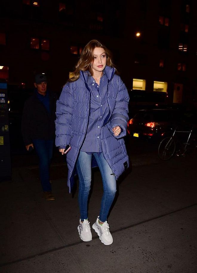 Gigi matches her cosy, blue puffer coat by Phillip Lim with a striped button-down shirt. This is how you do winter chic! 