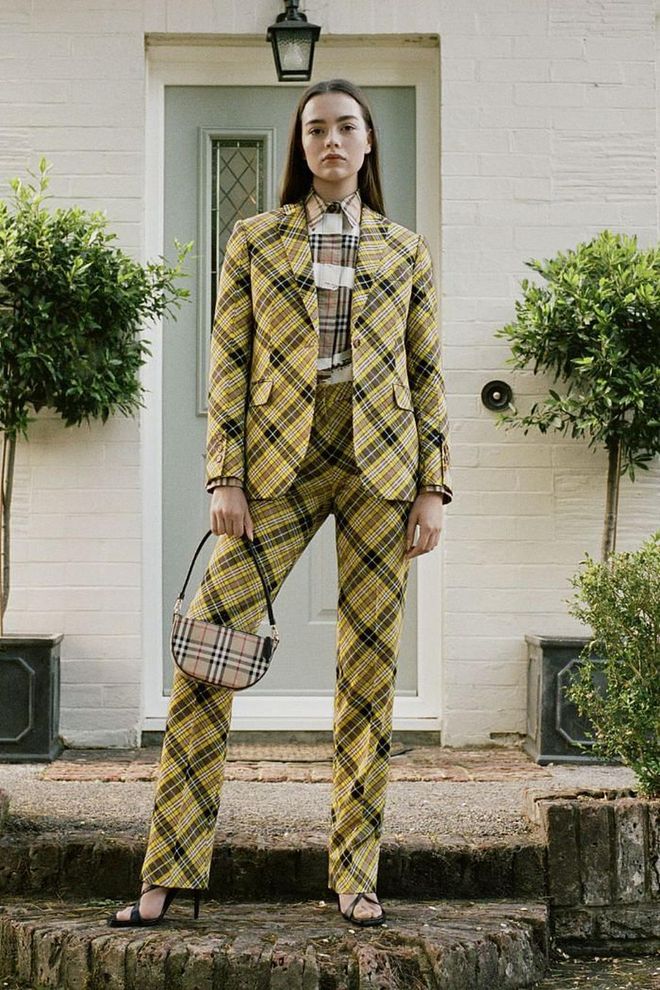Burberry is keeping its Resort 2021 collection close to home—going so far as to shoot each person in the seasonal lookbook outside of their respective front doors in England. That British energy extends to the clothes themselves—leveraging plaid suiting, trench coats with the logo splashed across them, and even and English garden motif. Chief Creative Officer Riccardo Tisci explains that insular vibe in a release: "This season, I wanted to draw upon the familiar, the things that bring us comfort and strength. I returned to what first inspired me in the Burberry heritage house codes, like the check, iconic stripes and unicorn emblems, but revisited them with a new perspective, incorporating elements of both sophistication and street through the lens of the outdoors."