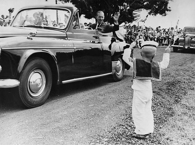 Prince Philip waves to four-year-old Michael McCarthy during a tour of Mackay in Queensland.