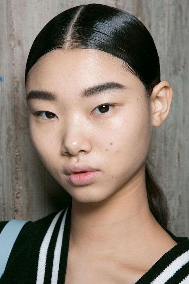 The ponytails at Loewe were center-parted and finished with a high-shine gloss. 