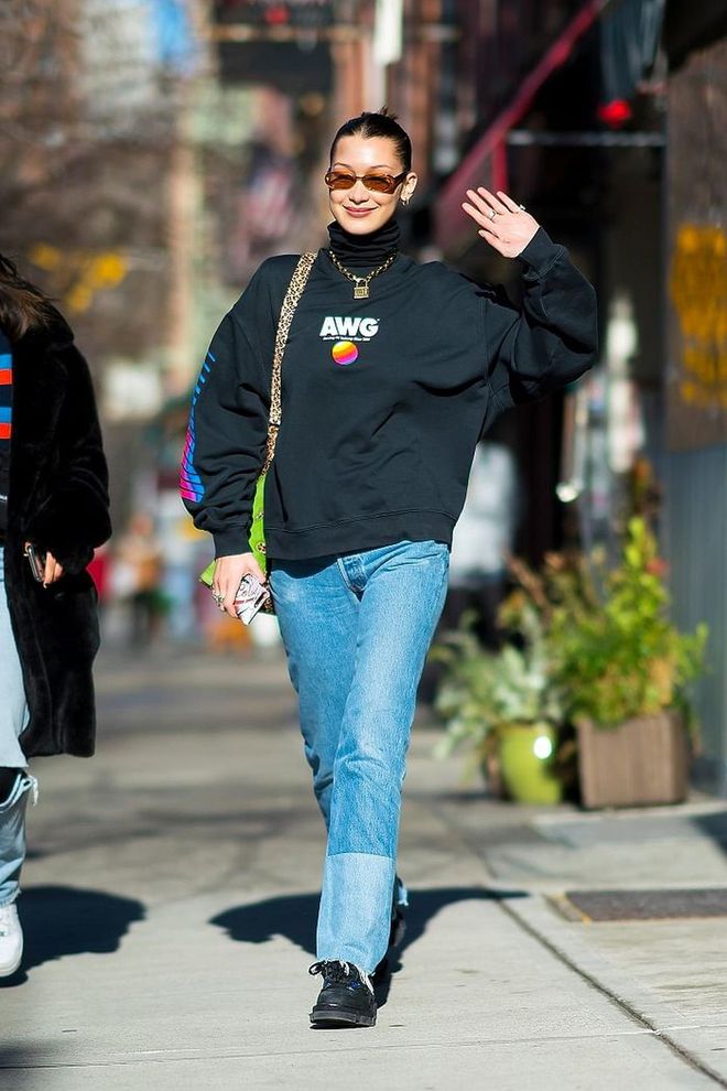 In a black oversized, retro sweatshirt and two-toned jeans. Photo: Getty 