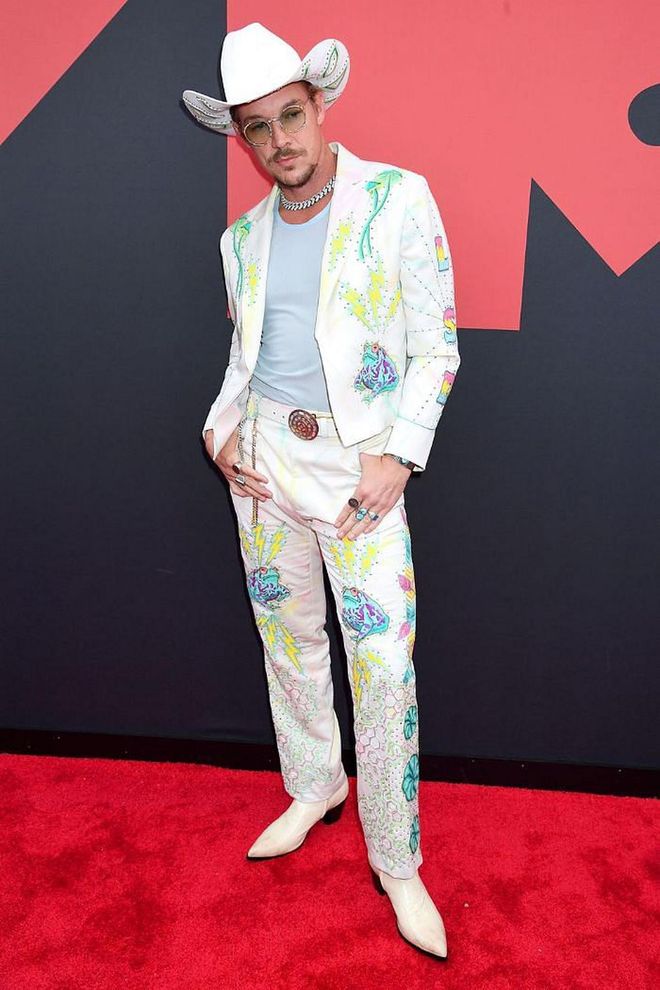 In a colorful print suit, matching cowboy hat, and white cowboy boots.

Photo: Getty