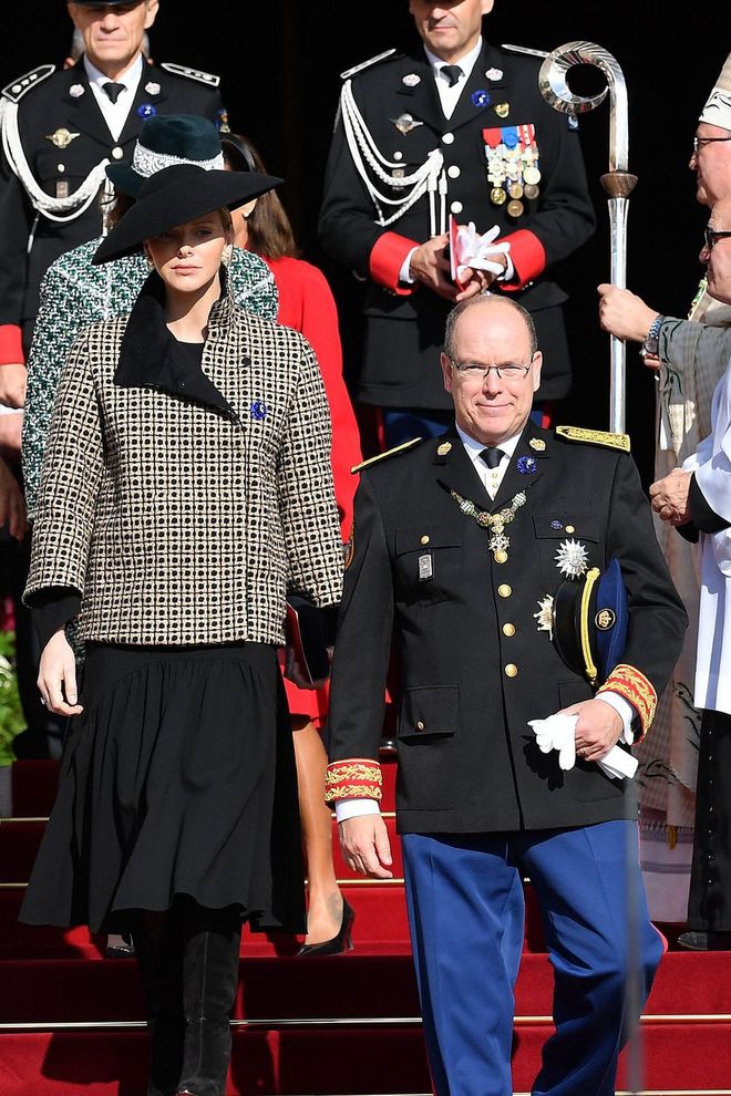 Prince Albert II dons military dress for the special occasion while Princess Charlene paired a gold and black patterned coat with a mid-length black dress, boots, and a black saucer hat.

Photo: Getty