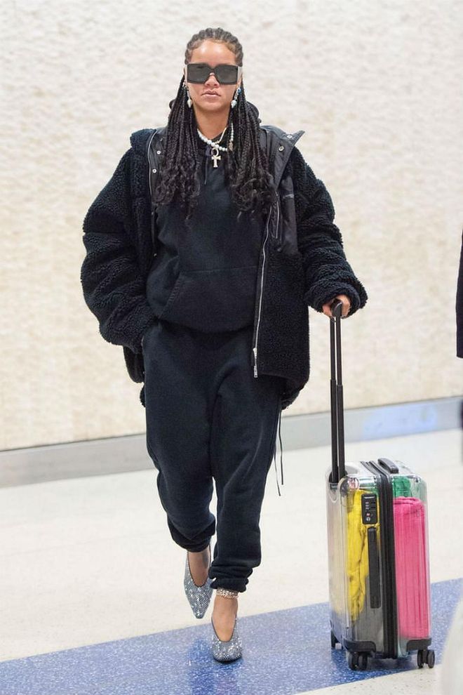 The Fenty Beauty founder has served up impeccable airport style yet again, wearing a baggy sweatpants and sweatshirt combo paired with a sparkly pair of Bottega Veneta heels. She completed her outfit with a transparent Off-White x Rimowa suitcase.