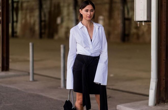 A guest wearing a shirt with wide sleeves, black skirt at day 3 during Mercedes-Benz Fashion Week Resort 18 Collections at Carriagework. Photo: Getty 