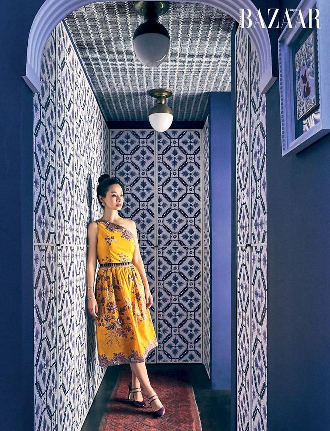 Amy Long, in a Dustbunny Vintage dress, Lee Gems & Fine Jewelry earrings and bracelet (worn
throughout), Cartier bangle (worn throughout) and Jimmy Choo pumps, stands out against her blue wallpapered wardrobe in the master bedroom.
