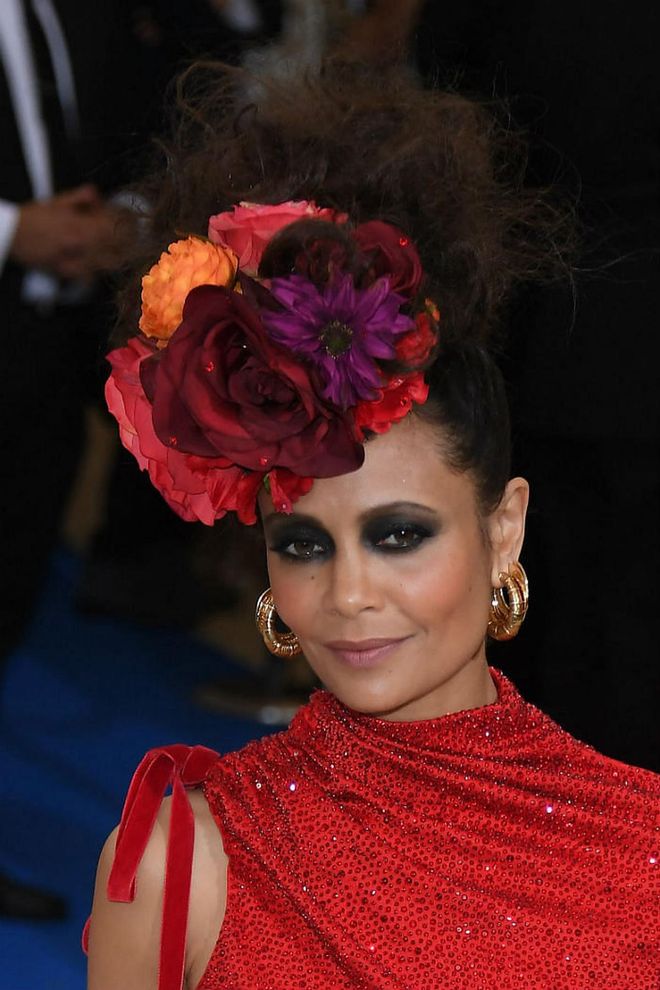Newton looks every inch a modern day Frida Kahlo with scarlet blooms sitting elegantly on her head. She swaps the unibrow with smokey eyes, and tones down the look with nude lips (Photo: Getty)