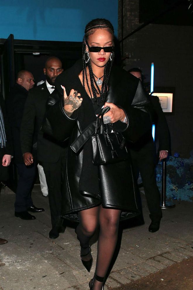 RiRi wore a leather trench coat, black sheer stockings, black pumps, silver jewelry and black shades for the British Fashion Awards after party.