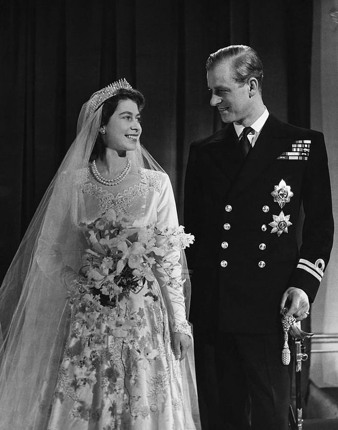 Elizabeth and Philip share a sweet moment on their wedding day. The couple tied the knot at Westminster Abbey on November 20, 1947. The future Queen's wedding gown included 10,000 seed pearls and a 15-foot train.