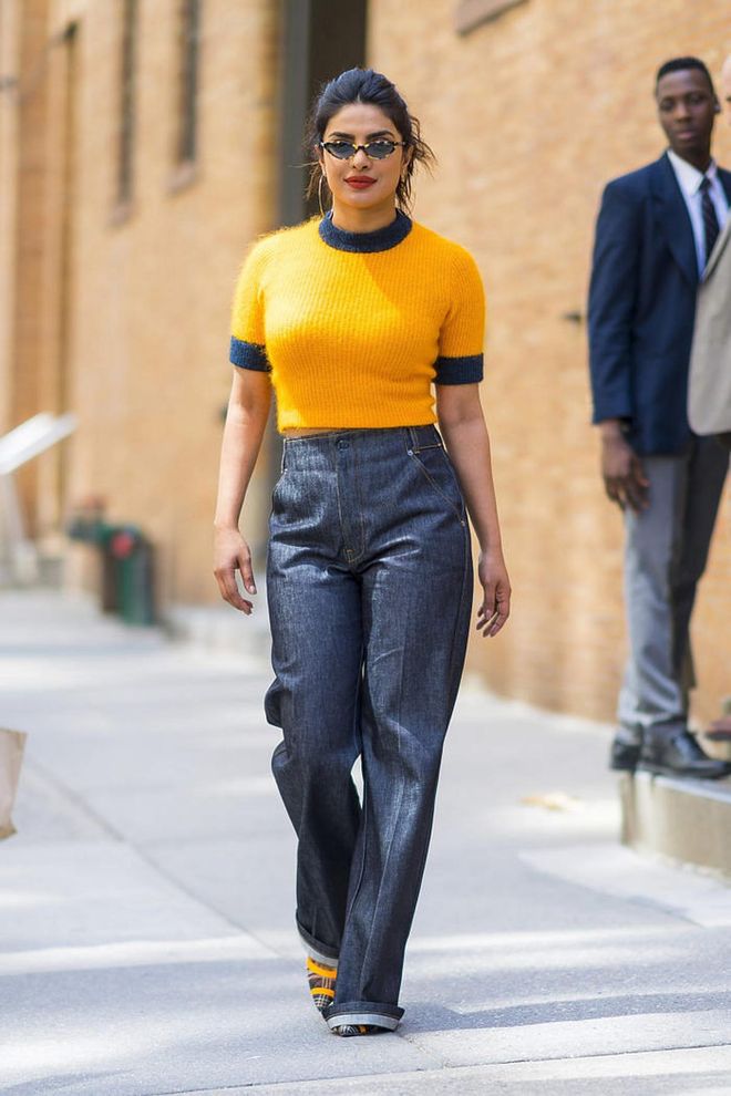 Fashion week ready in this canary yellow Ganni crop top, Frame Denim jeans and Fendi shoes with Vogue X Gigi eyewear. Photo: Getty 