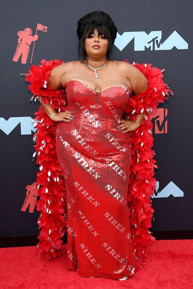 In a red hot "Siren" Moschino gown and matching feathered boa.

Photo: Getty