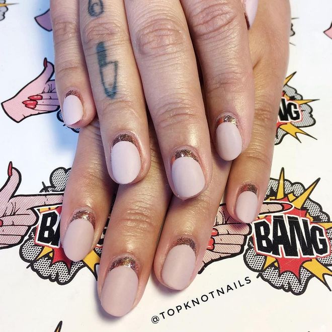 Think of the matte pink-nude polish as the ceremony, and the ring of gold glitter as the party. Photo: @topknotnails