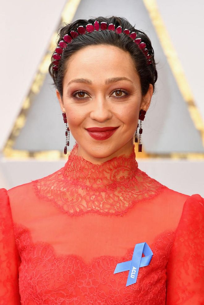 In addition to a crimson frock and the ruby-coloured headband, Ruth Negga cements her look with complementary makeup. 

Photo: Getty Images