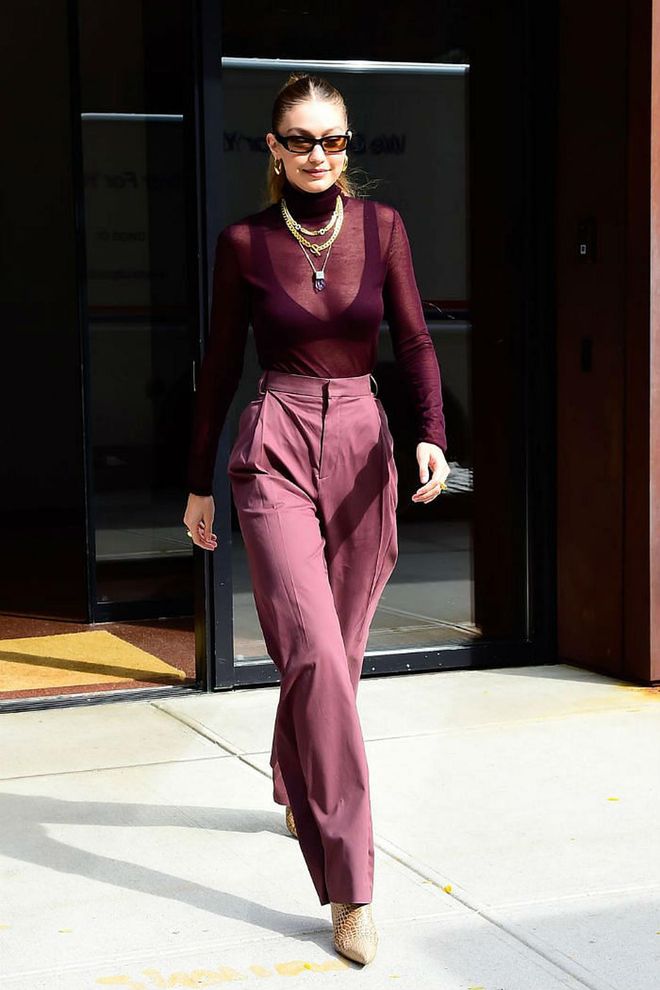 The model was spotted wearing a head-to-toe wine-coloured look: a sheer wine turtleneck over a bra, and high-waisted trousers. She styled the look with gold crescent hoops by Lili Claspe, gold chain necklaces, and pointed python boots.