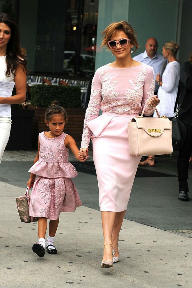 Taking pretty in pink to new heights, Jennifer Lopez and her daughter Emme stepped out in matching pink peplum dresses, each embellished with floral designs. While both mom and daughter accessorized with top handle bags, Emme wore socks and Mary Janes while J.Lo went for classic pumps.  Photo: PCN