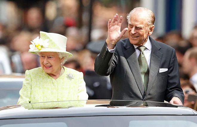 Queen Elizabeth II and Prince Philip look out of a Range Rover in Windsor after her 90th birthday celebration.
