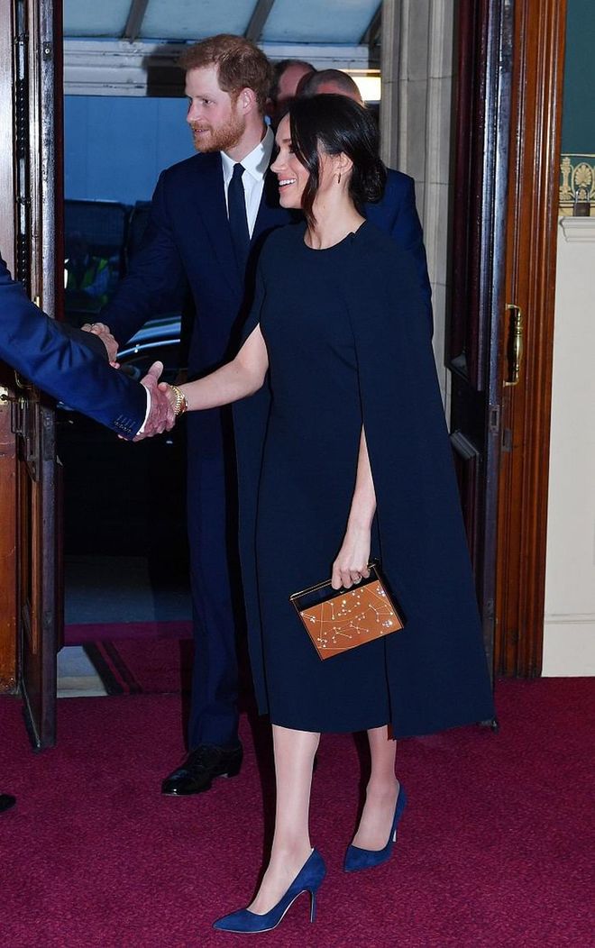 Meghan was matchy-matchy with Prince Harry at the Queen's birthday. She wore a navy caped dress by Stella McCartney and matching Manolo suede pumps. The Royal-To-Be carried a little rectangular clutch by Naeem Khan in a burnt orange shade. 