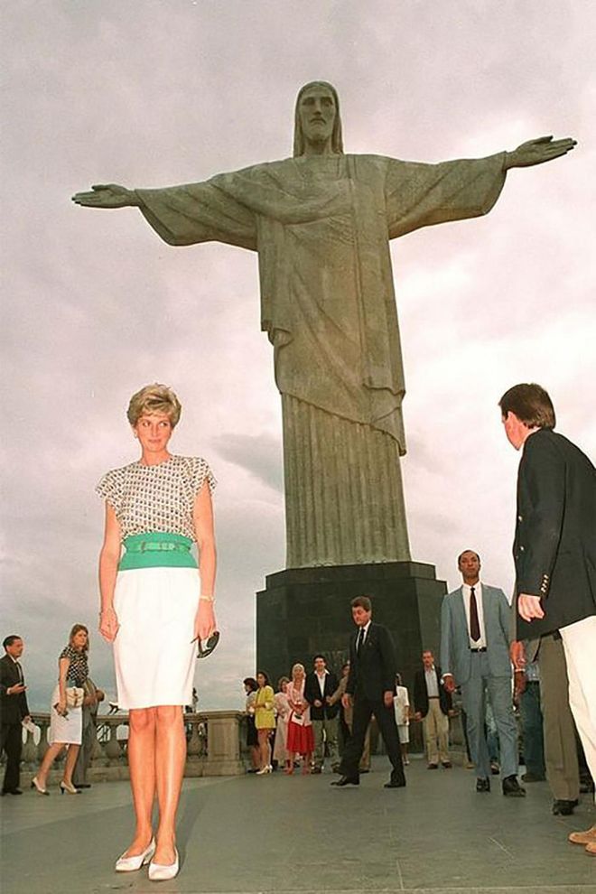 In a belted blouse and skirt while posing in front of the monument of Christ the Redeemer in Rio de Janeiro, Brazil.

