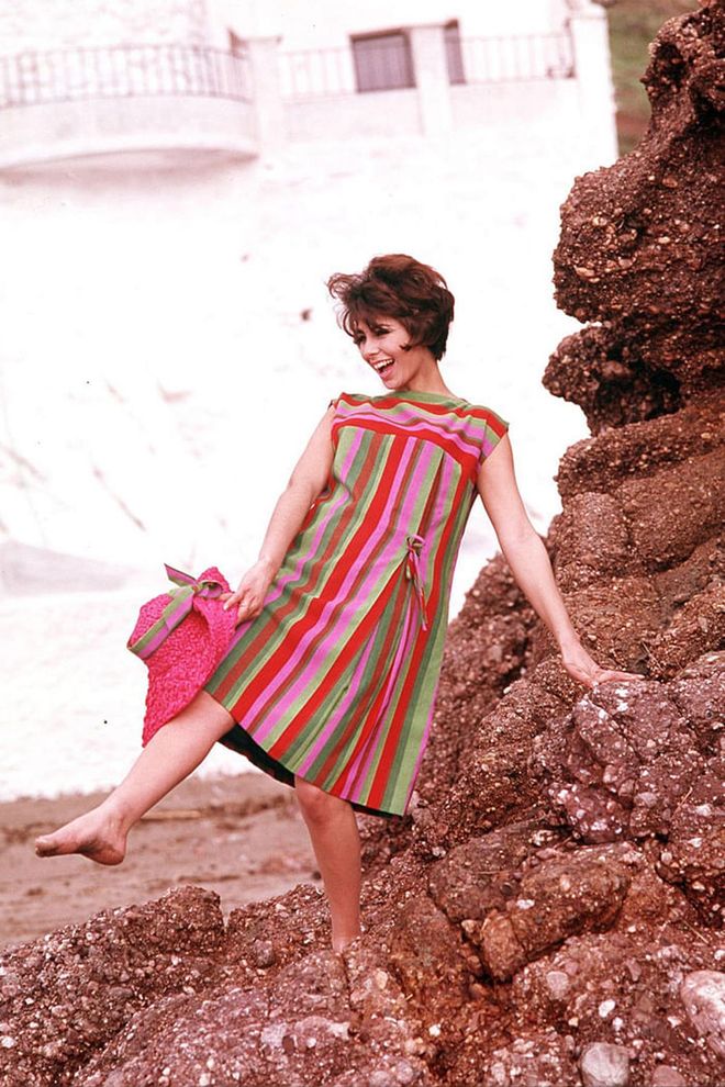 A woman in a colourful striped shift dress. Photo: Getty