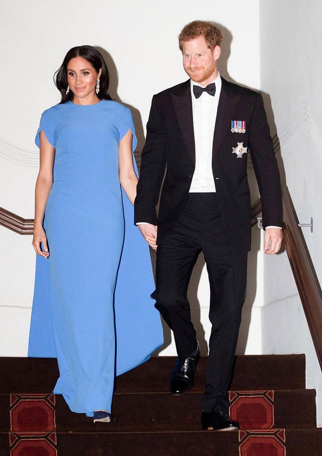 For a state dinner in Fiji, the Duchess dressed up in a bright blue caped gown by London-based designer Safiyaa. She accessorized with diamond drop earrings and a sleek blowout. Photo: Getty