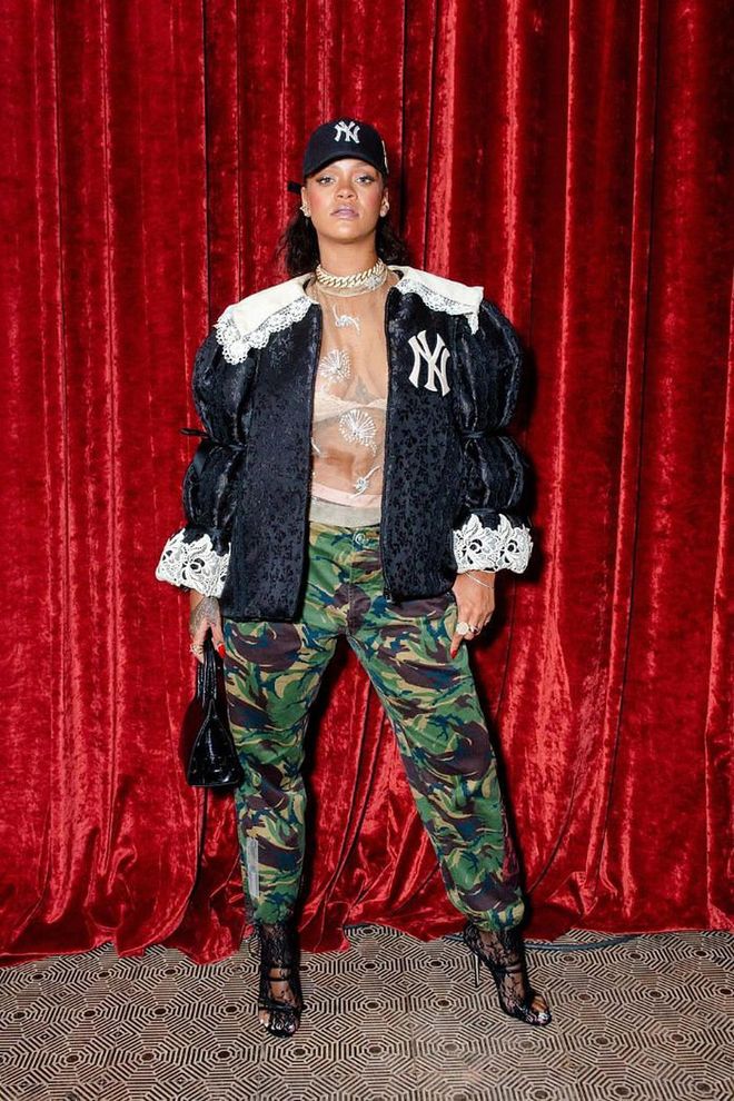 Rihanna rocks a Yankees cap, embroidered jacket, a sheer floral-printed top, camo-printed trousers and lace heels to the Gucci store opening on Wooster Street, New York.

Photo: Getty Images