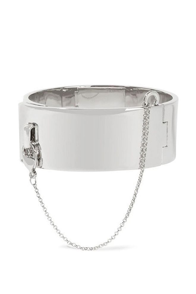 This glistening silver bangle is fastened shut using the safety-chain detail. 