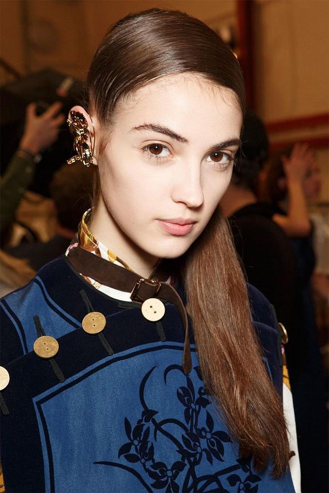 JW Anderson made a combover look impossibly chic (it helps when you're doing it for the purpose of showcasing ear jewelry). Models' hair was flipped over to one side, slicked down, and then gathered into a low, side ponytail.