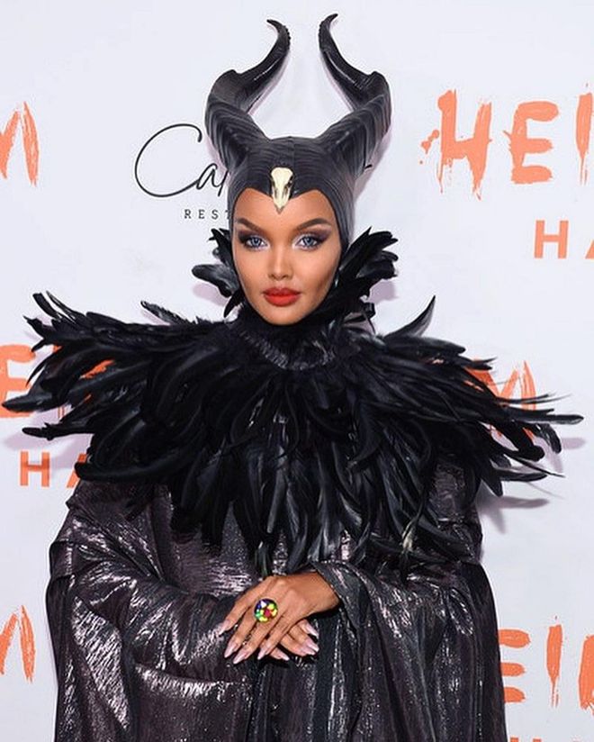 Model Halima Aden draped herself in shimmery black garb, feathers, and horns to become Maleficent, the evil witch from Sleeping Beauty.