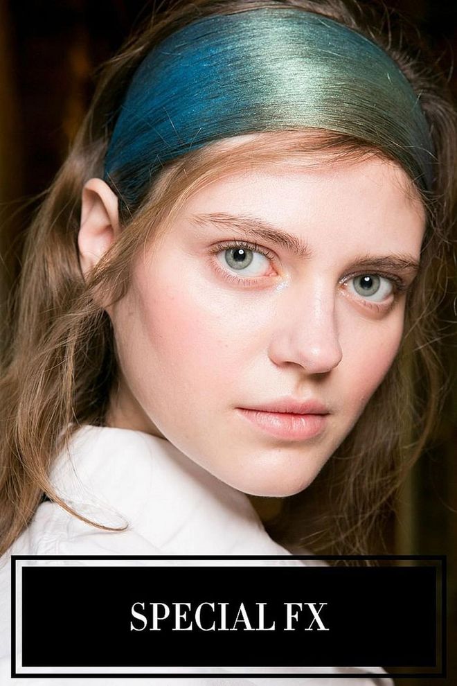 No, that's not a headband. That's the model's own hair, coaxed and smoothed into a headband, then spray painted to reference the aurora borealis backstage at Issey Miyake. Is it an odd look and technique? Sure. But the end result—soft waves falling behind a metallic, glittery blue-and-green hairband—is one of the most stunning and inventive hairstyles we've seen all season. It joins a handful of other shows where what was put in the hair made more of a splash then the hair itself.