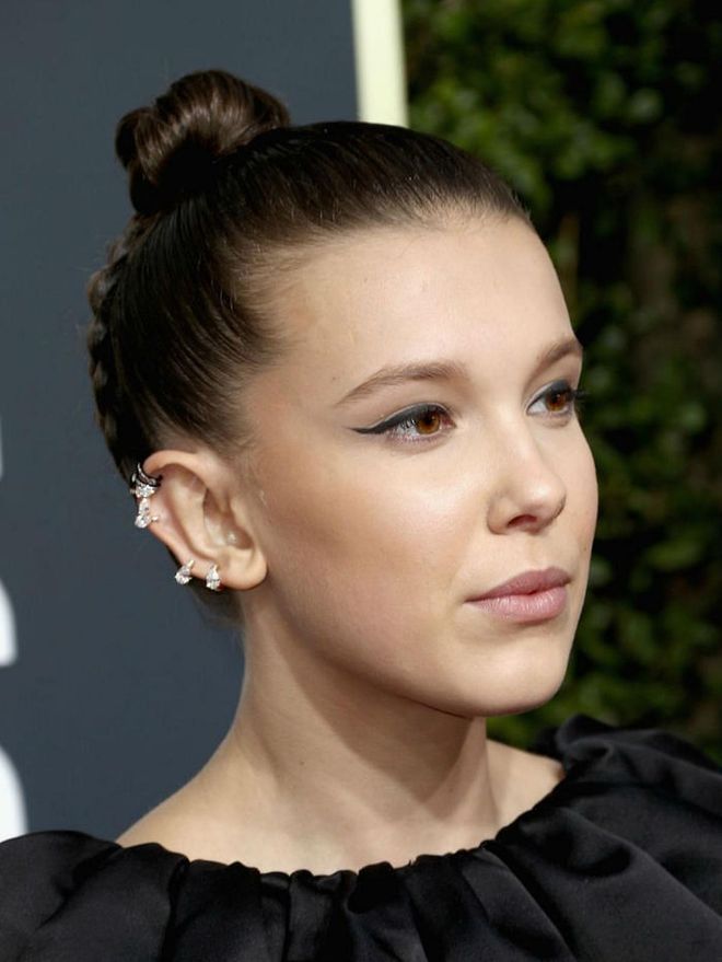 An extended flick of eyeliner adds edge to Millie Bobby Brown's ensemble.
