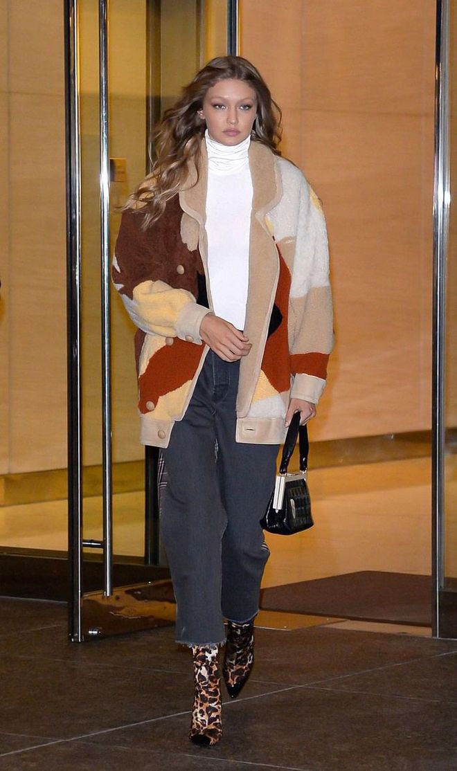 Gigi looking very cozy in a brown patchwork cardigan by Tods over a Wolford white turtleneck and grey Monse jeans. She completed the look with a pair of leopard print Giuseppe Zanotti boots. 