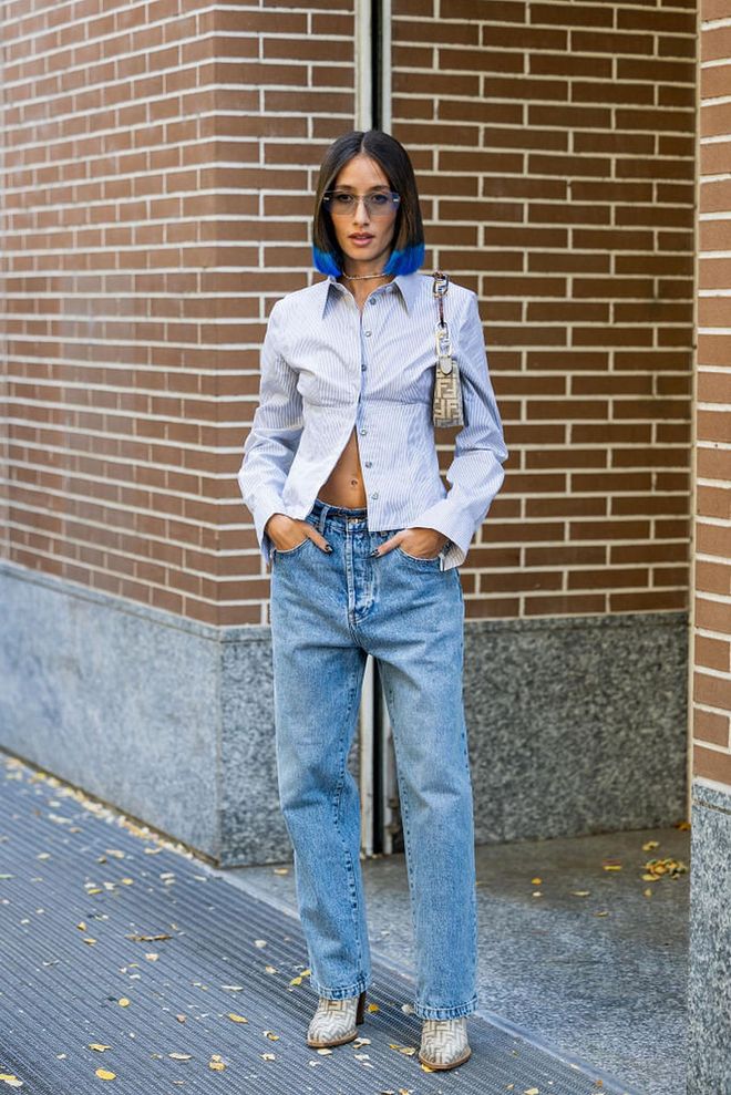 MILAN, ITALY - SEPTEMBER 21: Alexandra Guerain wears blue white button shirt, bag with logo print, denim jeans, ankle boots outside Fendi during the Milan Fashion Week - Womenswear Spring/Summer 2023 on September 21, 2022 in Milan, Italy. (Photo by Christian Vierig/Getty Images)