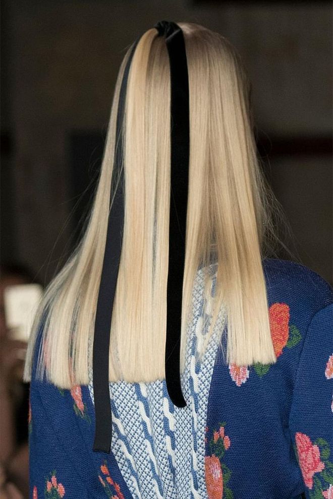  At Emilia Wickstead, hair was pulled into a small half-up section and then secured with a black ribbon. The ends were left hanging loose—not knotted—for a less sweet effect.