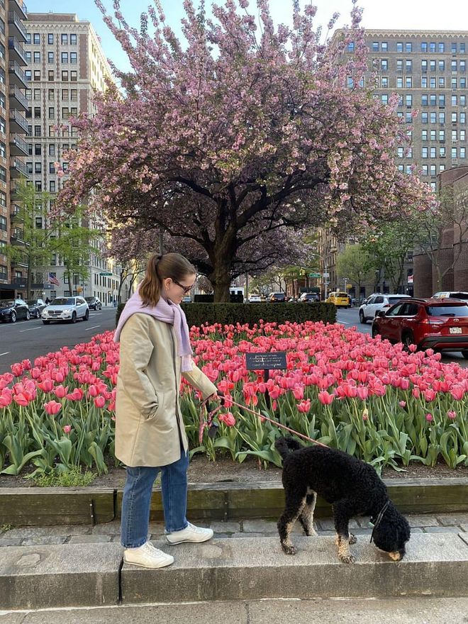 Halie walks her dog in Onitsukas, plus an Asket coat, Asket jeans, Warby Parker sunglasses, and a Mango sweater tied as a scarf. 
Photo: HALIE LESAVAGE