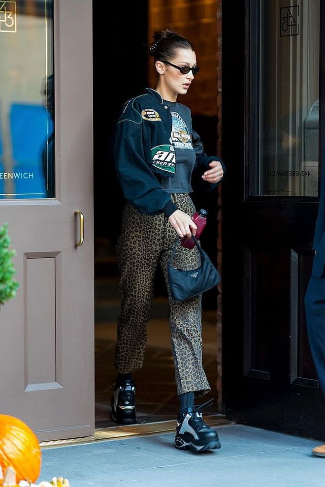 Bella spotted in New York in a casual outfit that featured leopard print pants, a vintage tee and jacket. She accessorised with a nylon Prada handbag.  
