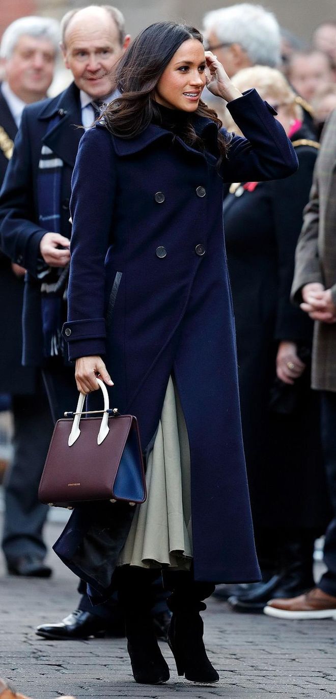 Meghan also wore a classic navy wool coat from Mackage and accessorized with the now famous Strathberry Midi Tote (after which the bag sold out in minutes). 