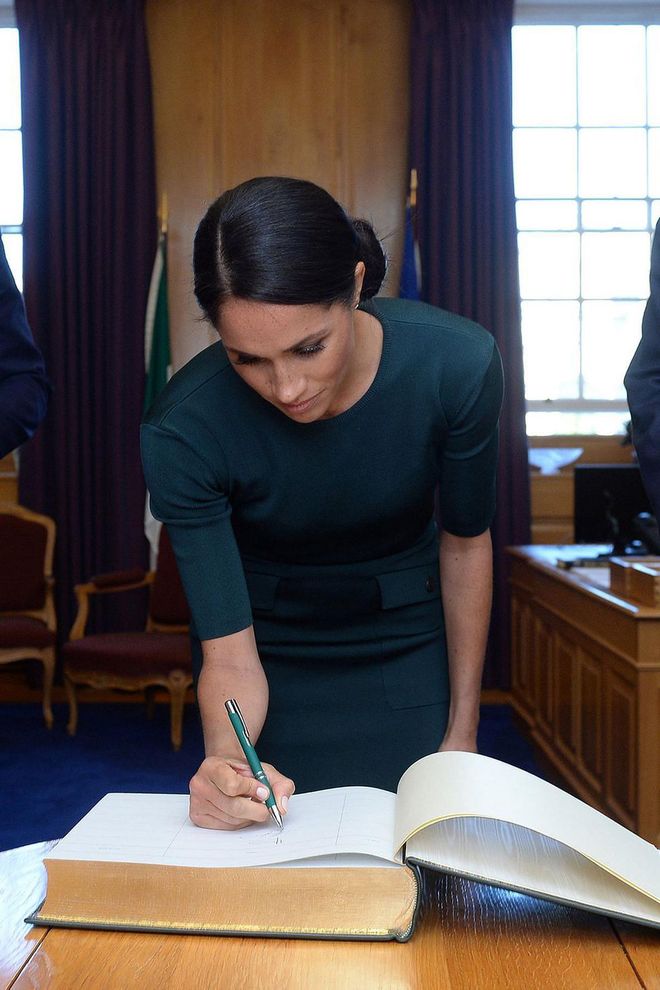 Meghan signs a guest book in Varadkar's office.

Photo: Getty