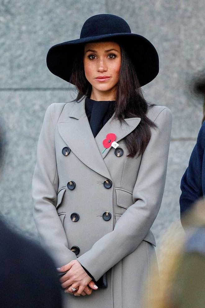 Meghan channeled her inner Kate Middleton this time. She wears a double-breasted grey trench coat by Smythe and black wool wide-brim hat. She carried her necessities in a small Gucci black suede Dionysus. 