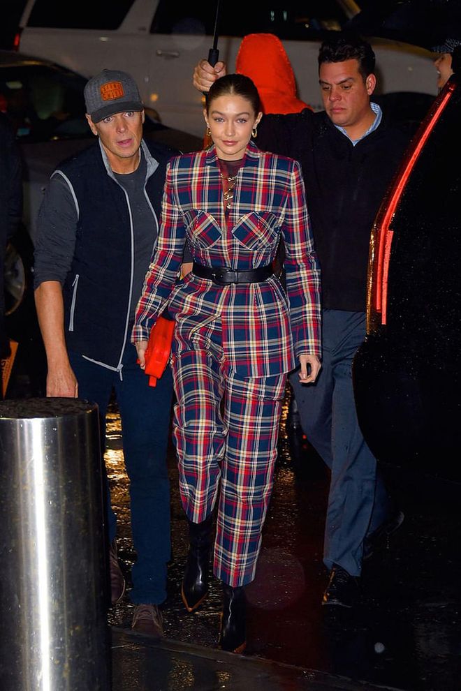 Spotted in a tartan suit by Esau Yori, Wandler ankle boots, earrings by Lili Claspe, and a pouch by Louis Vuitton. 