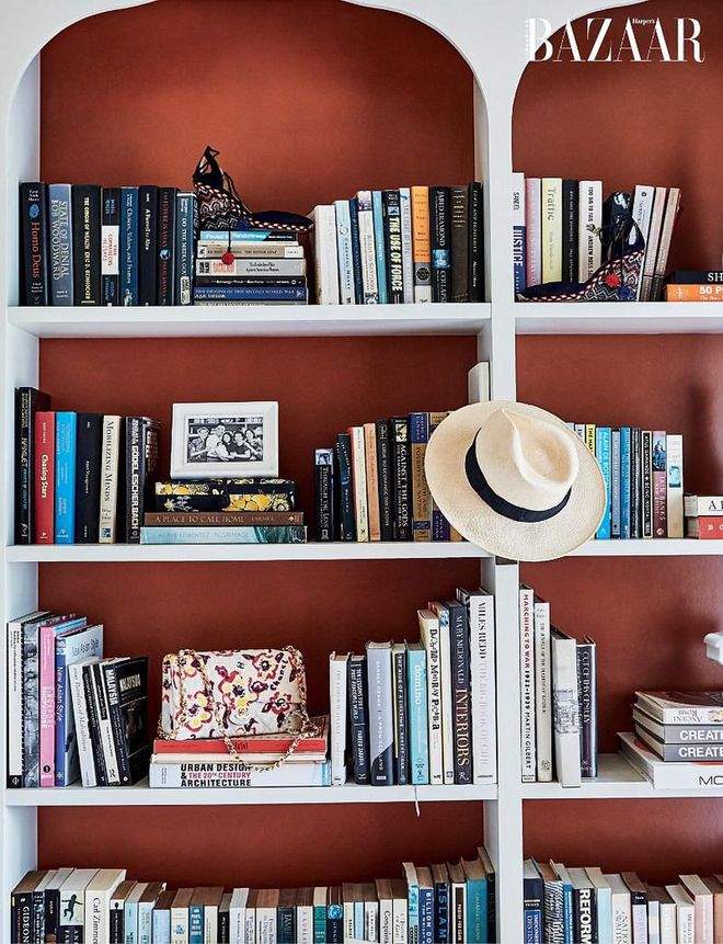 A bookshelf with Aquazzura wedges, a Hat of Cain topper and a Chanel bag among the
books.